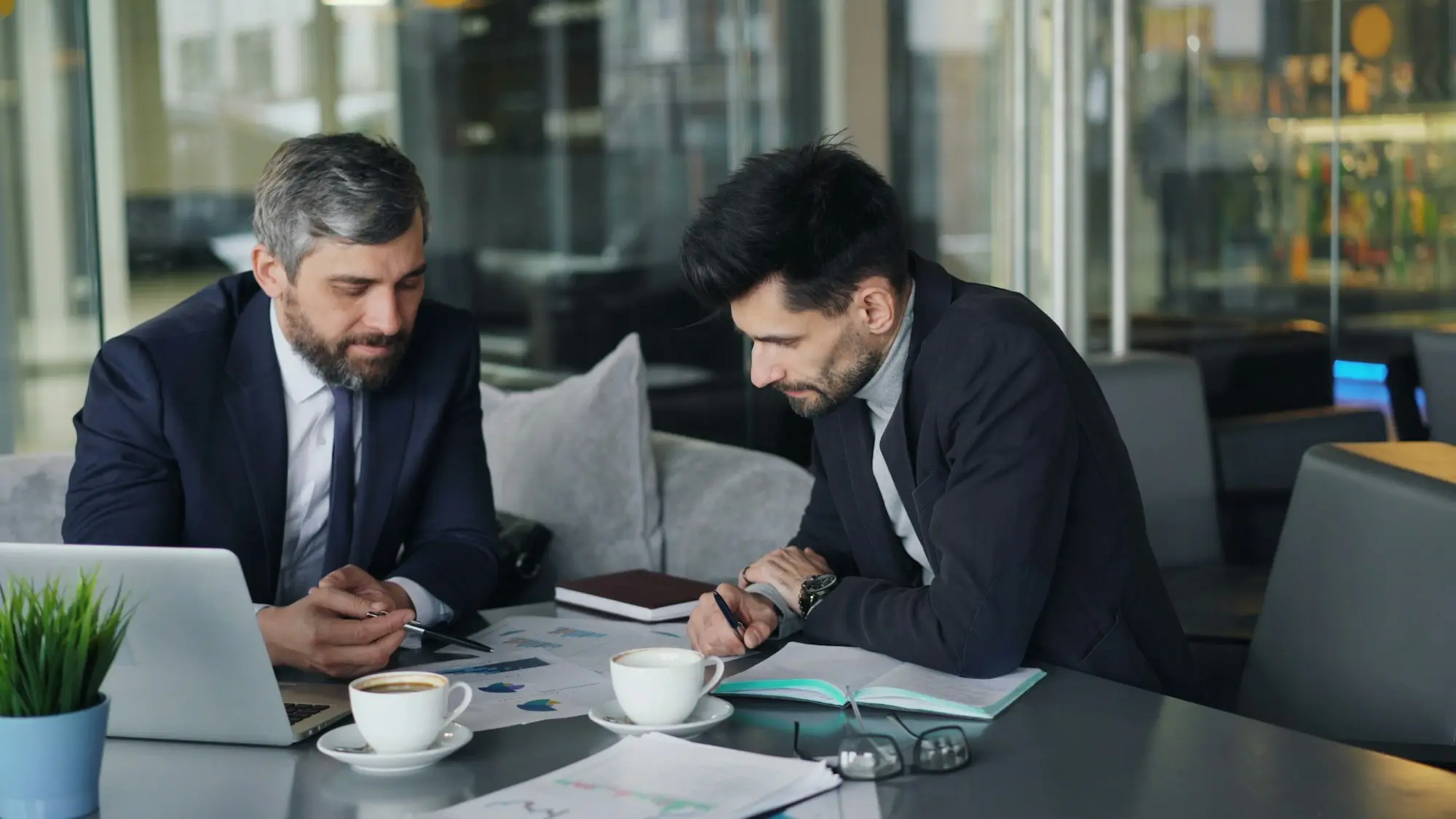 Two men working through a cash flow forecast on a laptop