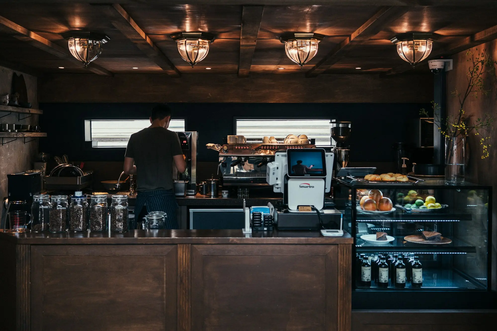 Cafe owner working the coffee machine behind the counter