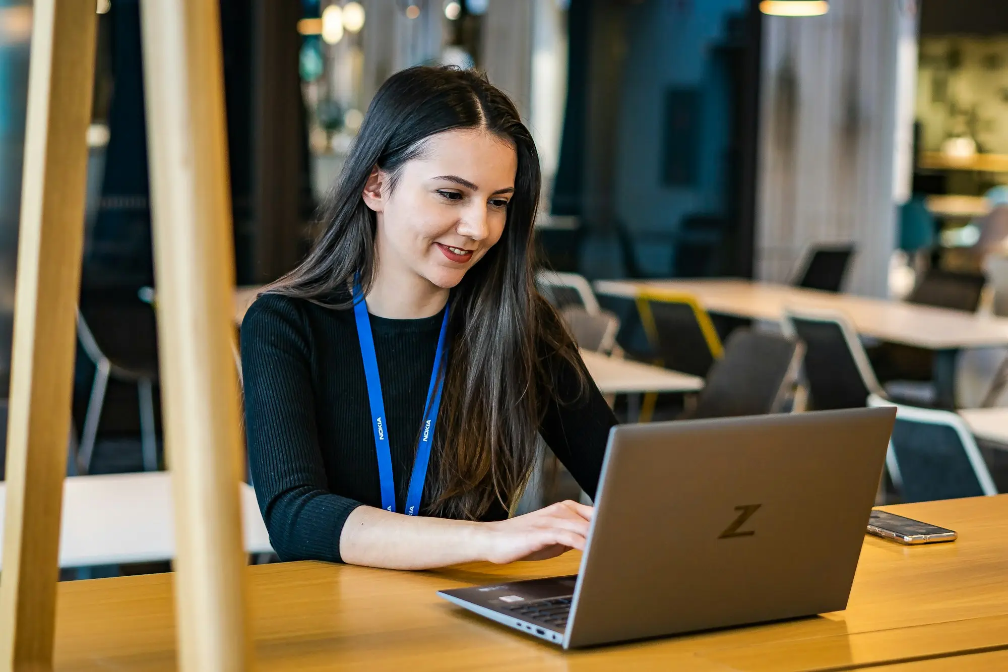 Director sitting at a table checking an account on a laptop